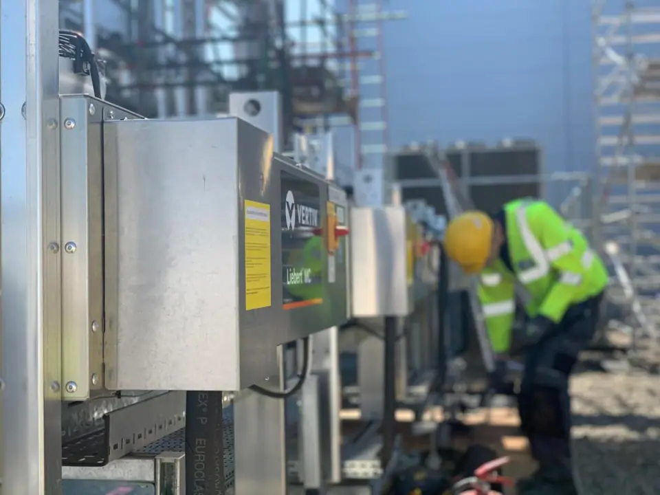 ChillTech engineer in hi-vis fitting a condenser unit and controls on a rooftop